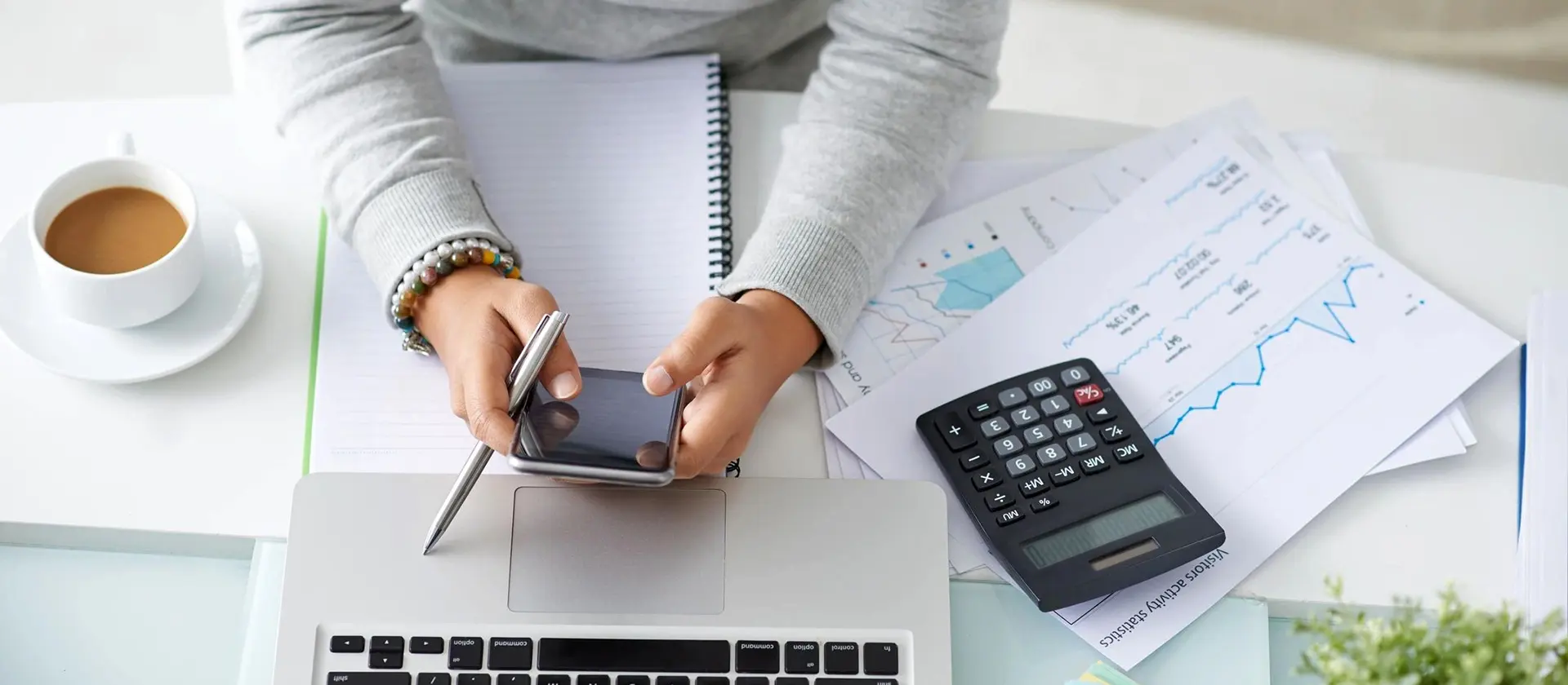 A working girl using a phone in front of the laptop